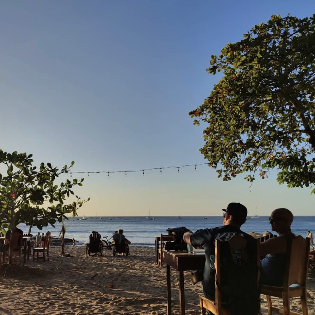 people sitting at a table on a beach